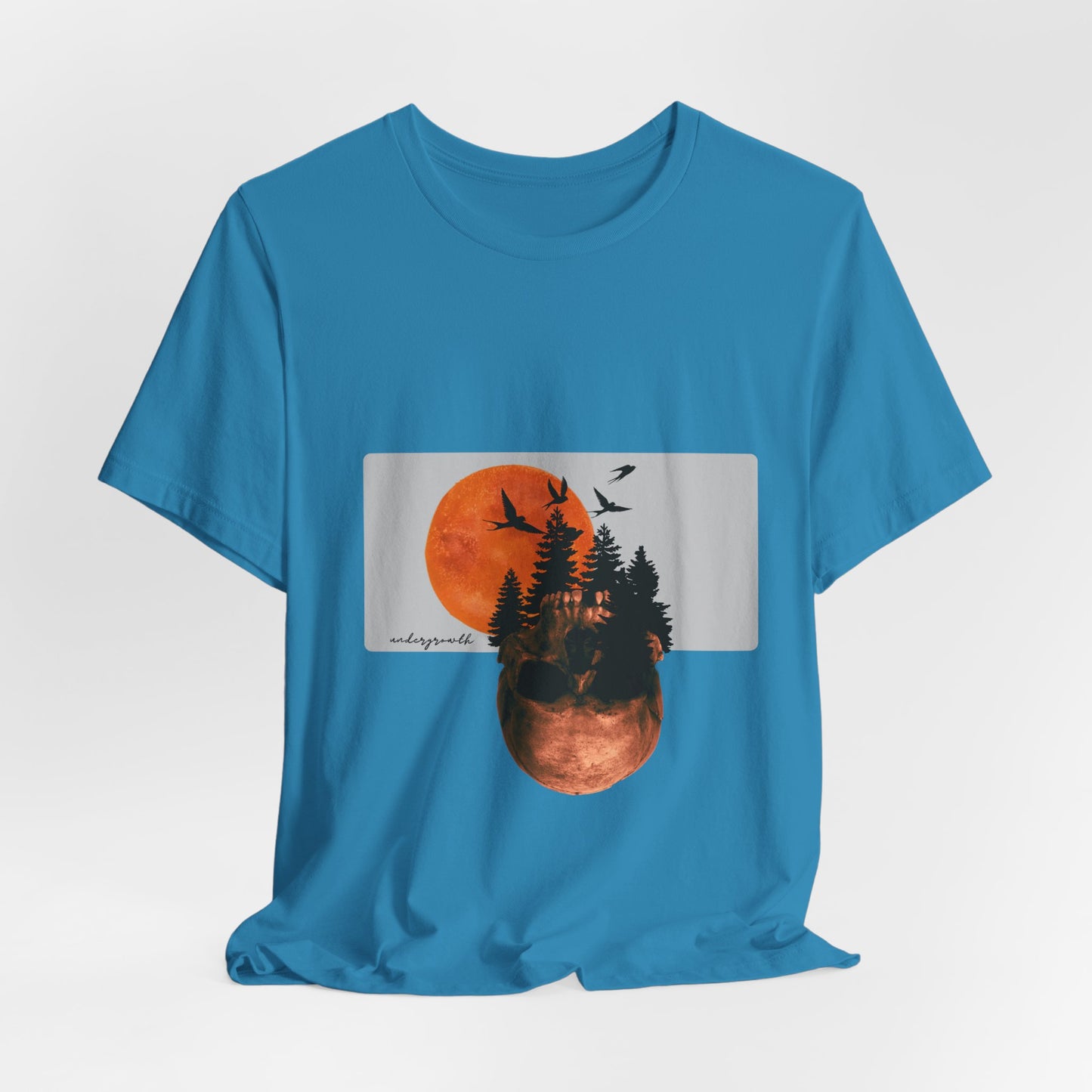 Blue t-shirt with a graphic of a sunset over trees and birds on a white background