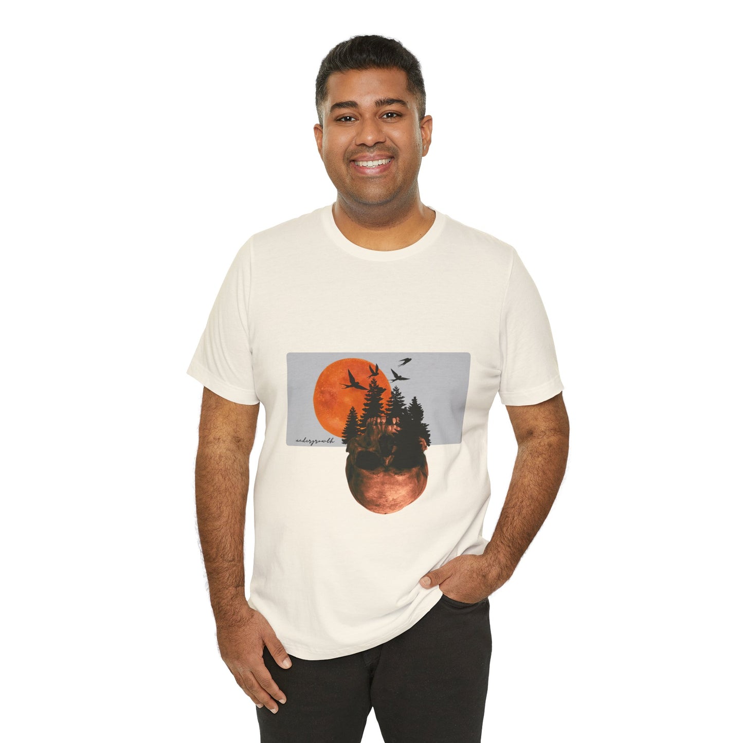 Man wearing a white t-shirt with a graphic design of trees and a moon on a white background