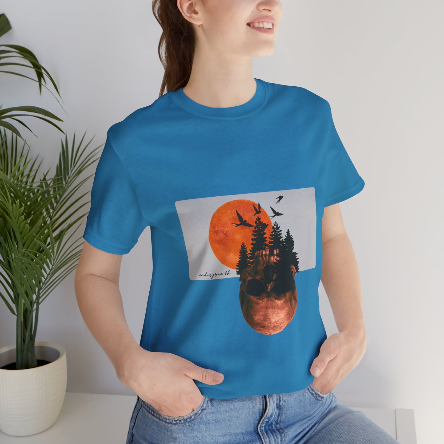 Person wearing a blue t-shirt with a nature-themed graphic design.