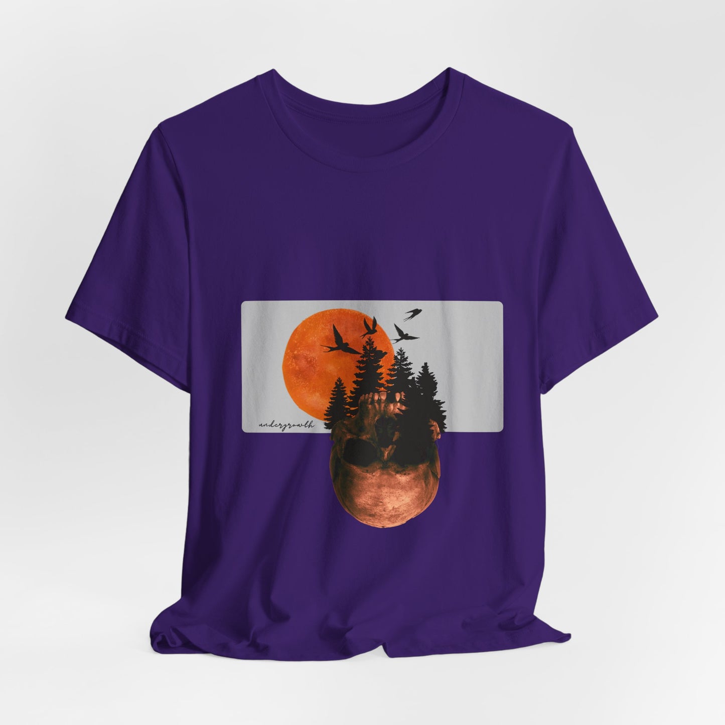 Purple t-shirt with a graphic design of a sunset over trees and birds on a white background