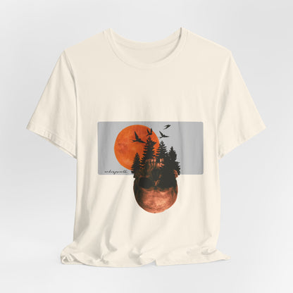 Beige t-shirt with a graphic of a sunset over trees and birds on a light gray background